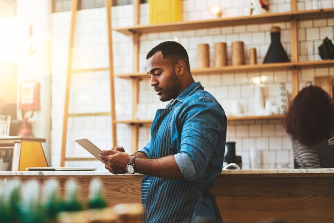 a man in his kitchen holding a tablet