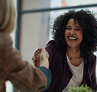 two women engaged in a handshake