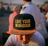 a person wearing a love your neighbor hat