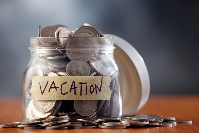 a jar full of coins with a vacation label on it